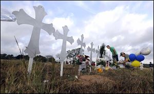 Kevin Blomstrum, left, and Kyle Dahlberg visit a makeshift memorial for victims near the scene of a shooting at the First Baptist Church of Sutherland Springs.