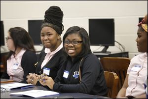 Dicnelle Gordon, 17, center, laughs as she and her classmates participate in an exercise led by etiquette instructor Robin Reeves during class Wednesday, November 8, 2017, at Jones Leadership Academy in Toledo. Ms. Reeves was working with students in the business program, called Young Executive Scholars, at Jones. The program is a partnership between the school and the University of Toledo's business college.  