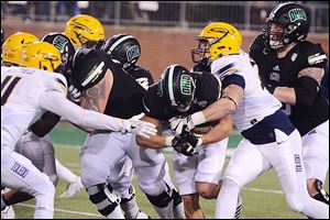 University of Toledo’s Marcus Whitfield and Zach Quinn bring down Ohio’s A.J. Ouellette.