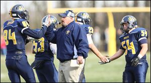 Whiteford head coach Jason Mensing congratulates Mathew Taylor (84) during the Bobcats' regional championship win. The Bobcats are 13-0 and in the state championship game for the second year in a row. 