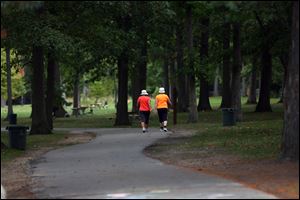 Two walkers make their way down the trail in Olander Park in October.