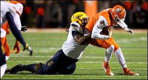 Toledo defensive tackle Marquise Moore, left, sacks Bowling Green quarterback Jarrett Doege during the first half of Wednesday’s game.