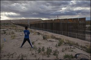 A youth looks at a new, taller fence being built along U.S.-Mexico border, replacing the shorter, gray metal fence in front of it, in the Anapra neighborhood of Ciudad Juarez, Mexico, in March of 2017.  A U.S. Customs and Border Protection agent was fatally injured responding to activity in Texas’ Big Bend area Sunday.