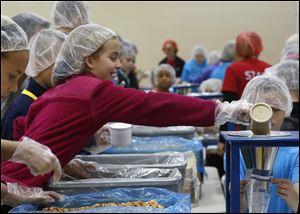 Students pack meals for hungry children in Africa in 2015. Maumee community members are working to pack 225,000 meals for starving children around the world this year.