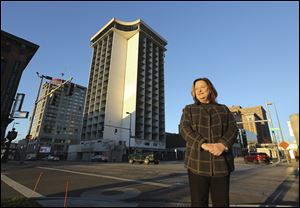 With the former Seagate Hotel behind her, Lucas County Commissioner Carol Contrada is pictured on Summit Street Friday, December 1, 2017 in downtown Toledo. The county commissioners announced Tuesday a partnership with Key Hotel and Property Management LLC to redevelop the partially demolished, county-owned 19-story building at 127 N. Summit St. into a “dual brand” Hilton Garden Inn and Homewood Suites.