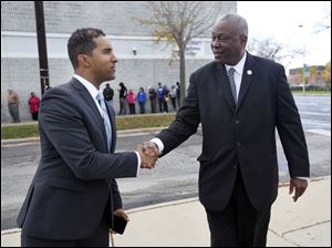 Mount Vernon Mayor Richard Thomas, left, shakes hands with State Rep. Michael Ashford (D-Toledo) during a voting event in 2016. Mr. Ashford is proposing an idea to fill the vacant Lucas County treasurer spot, but it may serve fellow politicians more than the community. 