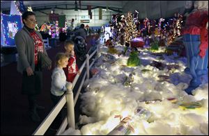 Kristina Biederstedt, left, and her children Kyndall Biederstedt and Zain Biederstedt, marvel at one of the illuminated holiday scenes during the Children's Wonderland at  Tam-O-Shanter in December of 2016.