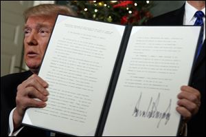 President Donald Trump holds up a proclamation to officially recognize Jerusalem as the capital of Israel.