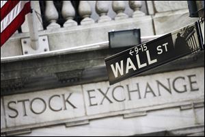 This July 16, 2013, file photo, shows a Wall Street street sign outside the New York Stock Exchange. Stock markets are mostly higher on Monday as upbeat U.S. jobs data from a week earlier and signs of progress in the Brexit talks continued to support investor sentiment. 