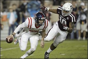 Quarterback Shea Patterson escapes a tackle by Texas A&M defensive lineman Daeshon Hall while playing for Mississippi in 2017. A Toledo native, Patterson is seeking immediate eligibility at Michigan.