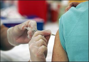 A flu shot is administered at a South Carolina pharmacy.