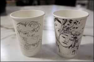Artwork created by Ben Carr, 17, of Bowsher High School, left, and Micah Inak, 17, of Lakewood High School is displayed on coffee cups Thursday, December 21, 2017, at Claro Coffee Bar.
