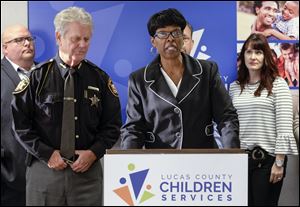 Robin Reese, of Lucas County Children Services, speaks as she and Sheriff John Tharp, left, announce a new partnership between DART and children services to better serve families with addiction problems during a press conference in October.