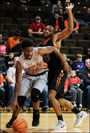 Bowling Green State University guard Justin Turner (10) drives past  Lourdes College forward McRay White. Turner ranks among the Mid-American Conference scoring leaders at 16.8 points per game.
