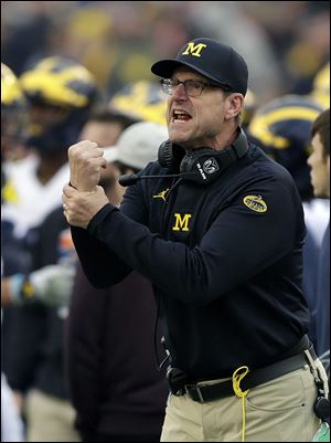 Michigan head coach Jim Harbaugh looks for a holding during the second half of the Outback Bowl.