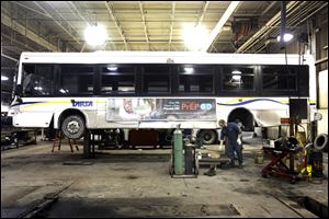 TARTA mechanic Rorric Russell works on replacing a set of disc brakes on a bus Thursday, at the main garage in west Toledo. The recent cold snap has made operating tricky for TARTA, and Mr. Russell said they were tackling a number of maintenance issues as a result of the cold. 
