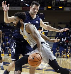 The University of Toledo's Tre'Shaun Fletcher dribbles past Akron's Mark Kostelac in a MAC game from earlier this season.