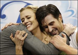 Madison Hubbell, center, and Zachary Donahue, right, hug a coach after as they react to their scores which won the pairs skate event at the U.S. Figure Skating Championships last month.