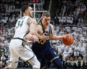 Michigan's Mortiz Wagner, right, drives against Michigan State's Gavin Schilling during the first half Saturday's game in East Lansing, Mich. Michigan won 82-72. 