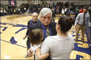 St. John's Jesuit head coach Ed Heintschel, center, is embraced after winning his 700th high school basketball game Saturday evening. The Titans beat Lakewood St. Edward, 59-45.