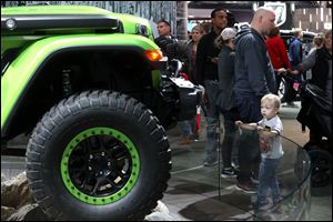 Commerce Township, Mich. resident Cameron Globish, 3, admires a Jeep Wrangler at the North American International Auto Show at the Cobo Center in Detroit.