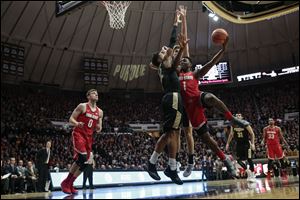 Ohio State forward Jae'Sean Tate, right, tries to shoot around Purdue defenders Vincent Edwards, left, and Matt Haarms on Wednesday.