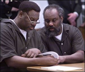 Nathaniel and Anthony Cook look over plea bargain paperwork during their sentencing at Lucas County Courthouse on April 6, 2000.