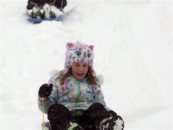 Children play while city crews work as snow blankets Lucas County