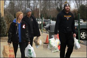 From left, Lourdes University students Shannon Fischer, C.J. Rilveria, and Brendan Brown transport donations for the Have a Heart Restock Drive to the Franciscan Center at Lourdes in Sylvania.