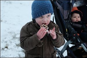 Wally Abke, 4, eats a s'more in front of his sister, Millie, 1, during Perrysburg's Winterfest.