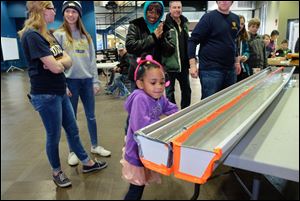 Razziahlynn Armstrong, 4, of Toledo, watches as the boat she made, and her choice of weight in it, puts her among the top scores in a contest created by the First Year Rocket Program, a group of first-year Engineering majors at UT.  