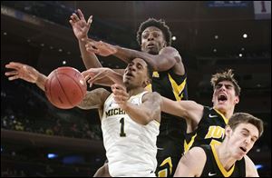 Iowa forward Tyler Cook, second from left, forward Luka Garza, second from right, and forward Nicholas Baer, right, stop Michigan guard Charles Matthews during the second round of the Big Ten conference tournament, Thursday, March 1, 2018, at Madison Square Garden in New York.