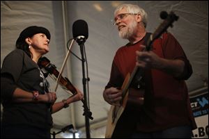 Amie Brodie, left, and Bruce Brodie, right, with Wolf Creek Risin’ play in the tent during Acoustics for Autism in 2017. This year's event is Sunday at Maumee's Village Idiot.