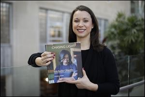 Former White House photographer Amanda Lucidon with her book, 'Chasing Light: Michelle Obama Through the Lens of a White House Photographer,' at the Main Branch of the Toledo Lucas County Public Library.