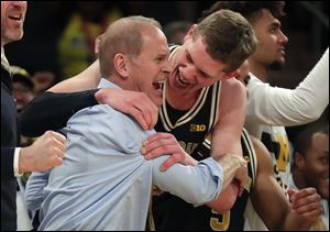 Michigan head coach John Beilein, left, celebrates with Michigan forward Moritz Wagner after Michigan defeated Purdue 75-66 to win the Big Ten Conference tournament championship.