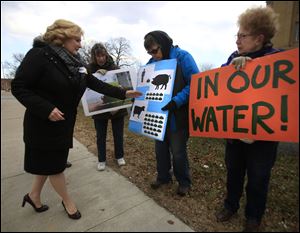 Ohio State Rep. Teresa Fedor (D-Toledo), left, speaks to demonstrators, from left, Kris Moazed, Marilyn Bernstein, and Pat McGlauchlin, during a picket by the Advocates for a Clean Lake Erie outside the Federal Courthouse in Toledo on Tuesday.