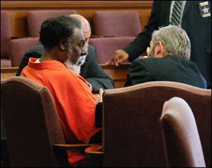 Convicted killer Nathaniel Cook huddles with attorneys Pete Rost and Sam Kaplan in Lucas County Common Pleas Court in Toledo.
