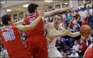 Archbold's Eli Miller looks to pass under pressure from Eastwood's Brendan Halko (10) and Grant Hirzel during a Division III district semifinal at Central Catholic High School. Archbold won, 53-45.