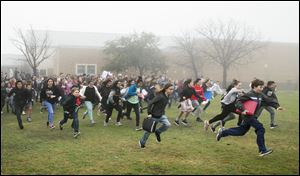 Bailey Middle School students run to the front of the school to begin a gun control protest on in Austin, Texas, on Feb. 23. School administrators attempted to keep the students out of sight behind the school before they ran to the front of the school.