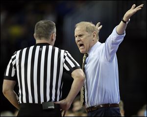 Michigan head coach John Beilein, right, complains to an official during the first half of Thursday's NCAA Tournament game against Montana in Wichita, Kan.