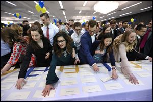 Fourth-year medical students at the University of Toledo grab their envelopes containing their residency placements during the annual Match Day ceremony at the Stranahan Great Hall Friday, March 16, 2017 in Toledo.