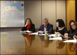 Lucas County Commissioners listen during a news conference at One Government Center about the feasibility of a downtown site for a new Lucas County jail.