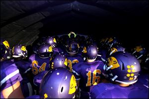 Maumee players prepare to take the field before a football game last season. 