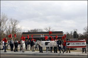 About 50 people with the Toledo-Based Farm Labor Organizing Committee rally together , April 11, 2018, outside the 7-Eleven on Bancroft Street near the University of Toledo. 
