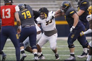 Rossford graduate Nate Childress (93) fights offensive linemen during the University of Toledo football spring game on April 13 at the Glass Bowl.