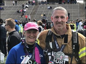 Springfield Township firefighter Thom Hites, right, ran the Glass City Half Marathon in full gear Sunday alongside his wife, Cathy.