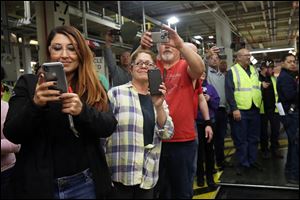 Workers snap photos and video as JK Assembly Center Manager James Gholston Jr. drives the final Jeep Wrangler JK off the line at 3:36 p.m. Friday at the Toledo Assembly Complex. 
