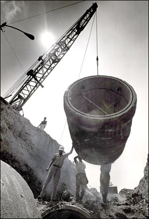 The final section of a new waterline that will boost Toledo's raw-water supply by 50 million gallons a day is dropped into place at the Collins Park Water Treatment Plant in July of 1967.