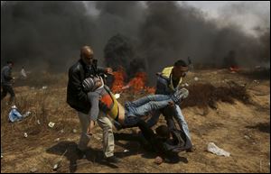 Palestinian protesters evacuate a wounded youth during a protest at the Gaza Strip's border with Israel, east of Khan Younis.