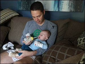 Kirk Brazeau feeds his infant Archer, his three-month-old who was born with a rare skin condition called Epidermolysis Bullosa. Epidermolysis Bullosa causes skin to suffer severe burns with even the smallest amount of friction.